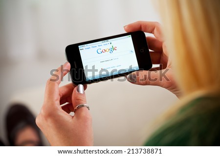 St. Louis, Missouri, USA - March 9, 2011: Woman Using Apple iPhone 4 To Access Google Website