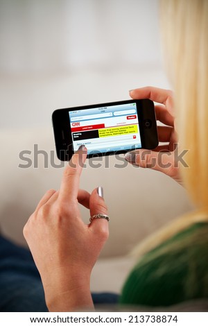 St. Louis, Missouri, USA - March 9, 2011: Woman Using Apple iPhone 4 To Browse News Site