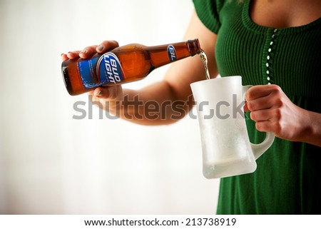 St. Louis, Missouri, USA - March 9, 2011: Woman Pouring Bottle Of Bud Light Into Mug. Bud Light Is Produced By Anheuser-Busch.