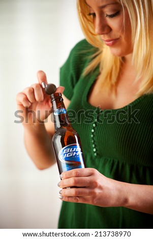St. Louis, Missouri, USA - March 9, 2011: Woman Twists Cap Off Of Bottle Of Bud Light. Bud Light Is Produced By Anheuser-Busch.