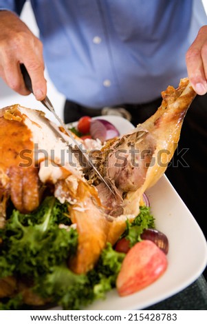 Thanksgiving: Man Slicing Off Roast Turkey Leg