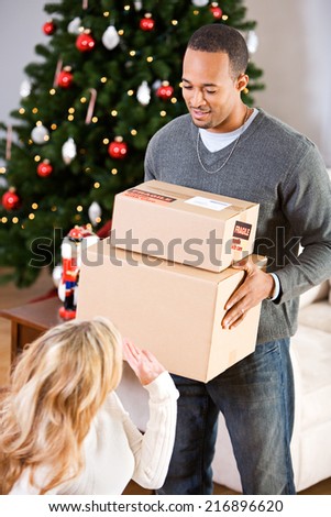 Christmas: Husband Carrying Stack Of Christmas Gifts For Shipping