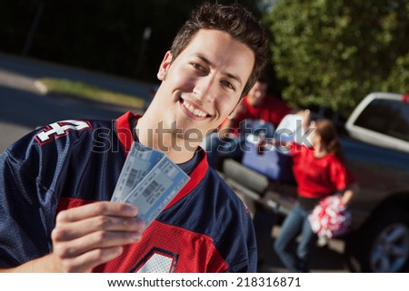 Tailgate: Guy Fan Holds Up Football Game Tickets