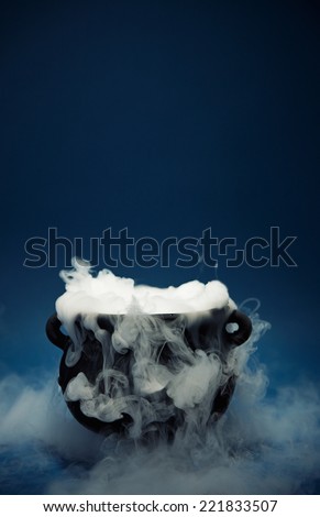 A spooky witch\'s cauldron with smoke coming out.