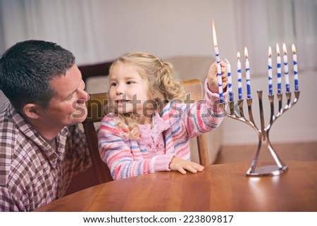 Hanukkah: Man And Daughter Light Hanukkah Candles