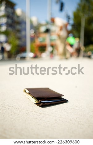 Lost Wallet On Sidewalk With Owner In Background