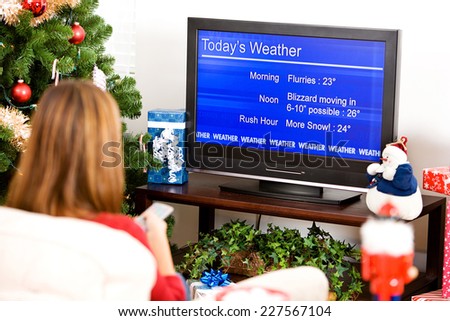 Christmas: Woman Watching Winter Weather Report On Television