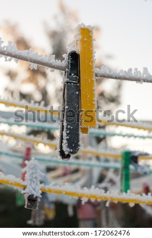 Freeze dried- frozen pegs hang from a rotary washing line on a cold icy winters day.