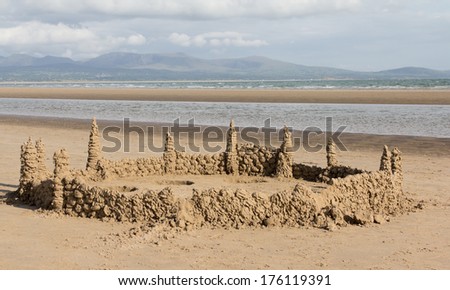 King of the castles. Large sand castle built on the sand on the beach at Newborough Anglesey,Wales with the Snowdonia mountain ranges as a backdrop.