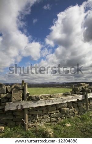 English Hunt jump over stone wall with Pennines in the distance