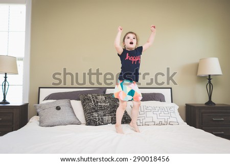 Little girl jumping on the bed