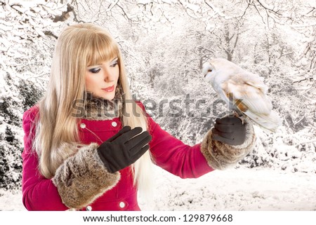 Winter portrait of a beautiful woman with a barn owl