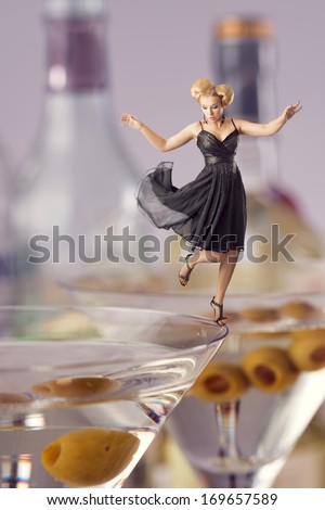 Woman partying on the edge of glass with alcoholic drink