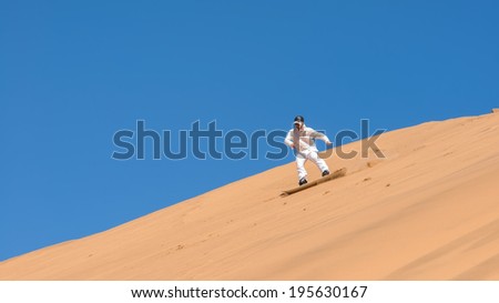 Man sandboarding in Namibia, Africa