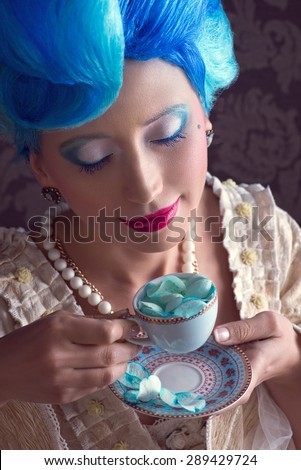 Baroque woman  with blue hair enjoying her tea