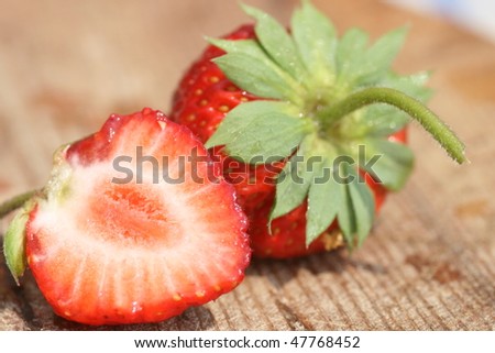 Red nice strawberry laying on the wooden desk
