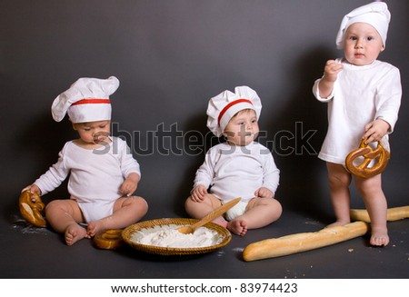 three  Cute little boy in a suit of Food Boy with kitchen accessories. In the studio