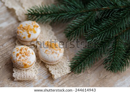 Macaroons and christmas spices on wooden ground