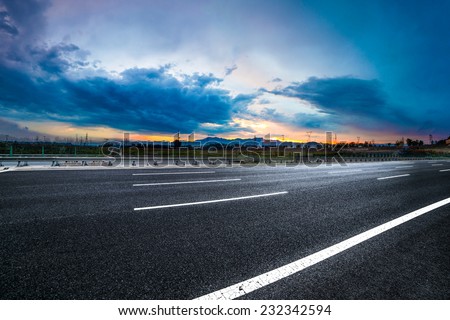 Asphalt road High way Empty curved road clouds and sky at sunset