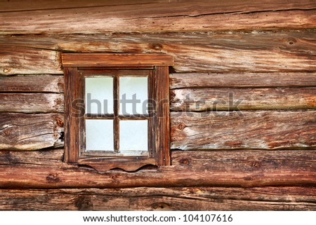 A small window in the wall of an old wooden house