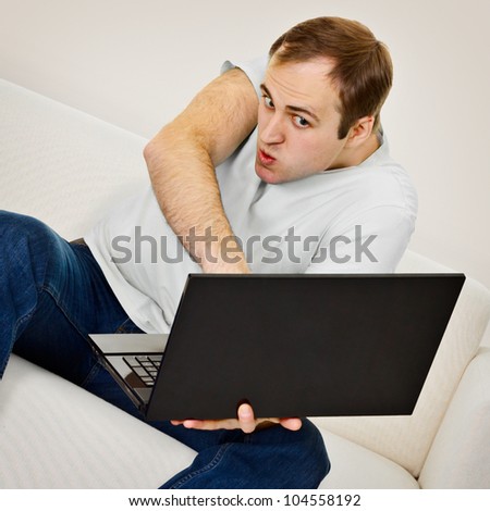 Comedic man plays on a computer at home