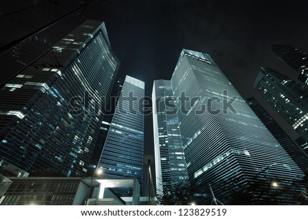 Photo of commercial office buildings exterior. Night view at bottom skyscrapers.