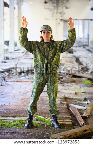 Woman in military uniform surrenders
