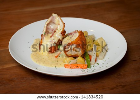 Chicken Cordon Bleu with boiled vegetables close up