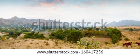 Indian nature. Panorama with mountains and goats in the evening