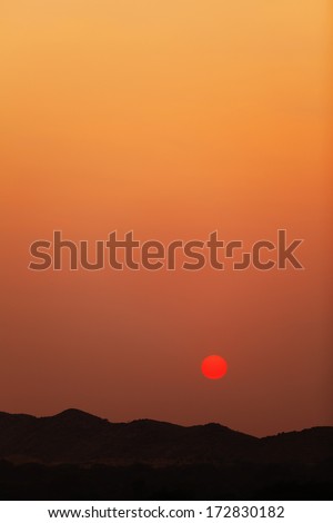The sunset over the hills. Vertical landscape