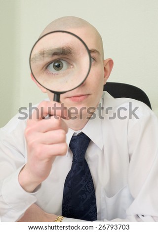 The guy looks through the big magnifier