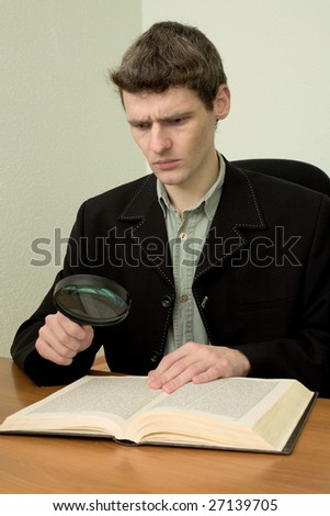 Man in black suit read book on a workplace