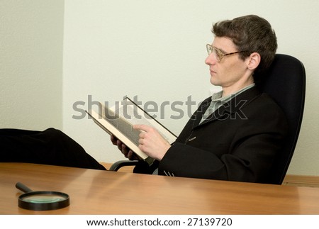 The guy in eyeglasses reads the book