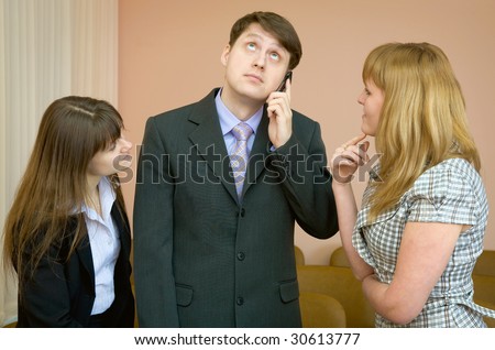 The man speaks by a mobile phone in the presence of two girls
