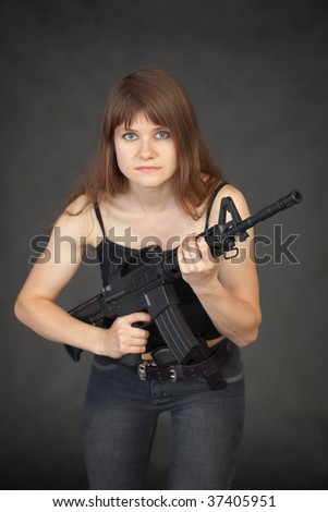 The beautiful young sexual woman with a rifle in hands
