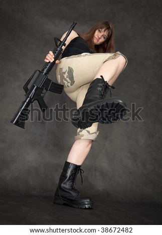 The furious woman with a rifle in hands kicks