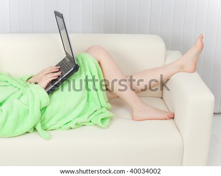 The young woman and the laptop on a sofa
