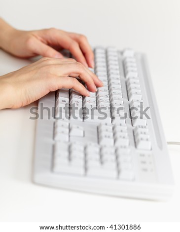 The grey computer keyboard and female hands working on it