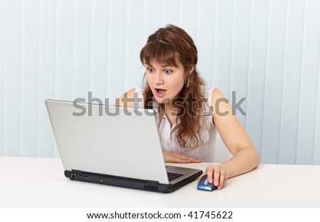 The indignant woman works in the Internet with the laptop