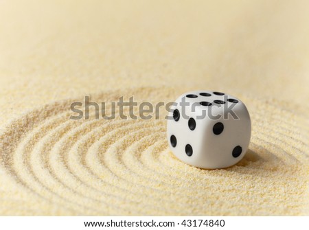 Playing white dice on a surface of yellow sand - an art miniature