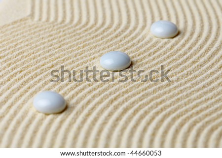 Art composition from white stones on a surface of yellow sand
