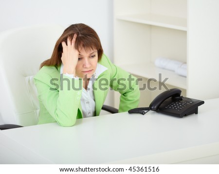 A sad young woman in the office at the workplace