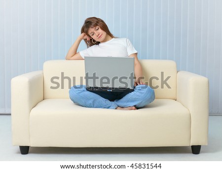 Tired after work woman reads with a laptop on sofa