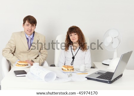 Business people - a man and woman meet for dinner at the workplace in the office