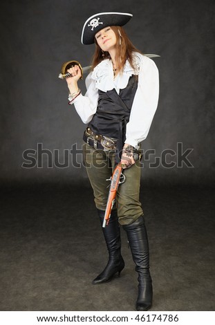 Girl dressed as a pirate standing on a black background with a sword