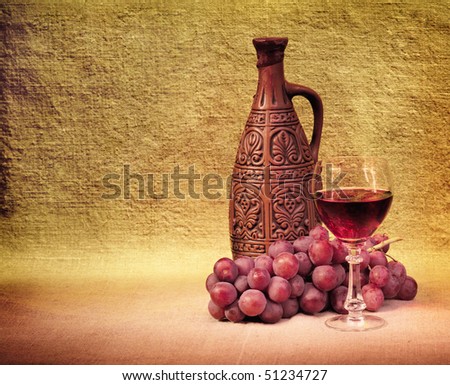 Artistic arrangement of bottles of wine, glass and grapes