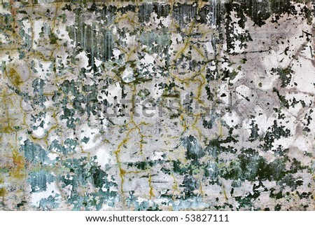 Cracked wall with fragments of old dark green paint