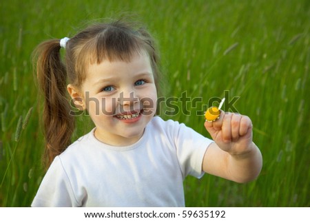 The little girl has torn off at a chamomile all petals except one