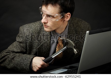 The person is going to break the computer by means of a hammer