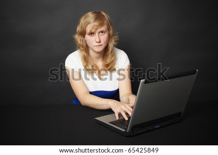 The young woman with the laptop works in the Internet in the evening